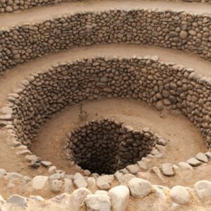 A downward view of the spiraling, stone-lined Cantalloc aqueducts, an ancient underground water system located in the dry Nazca desert in Peru.